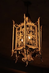 A vintage style chandelier with warm golden light illuminating a classic dining room