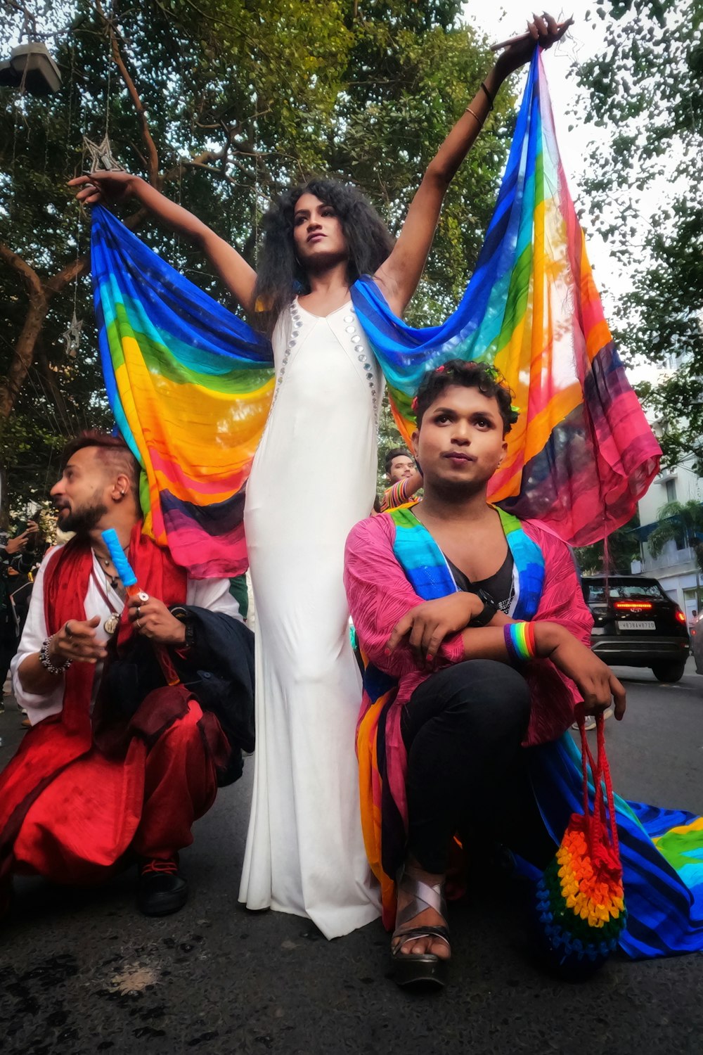 a woman in a white dress standing next to two children