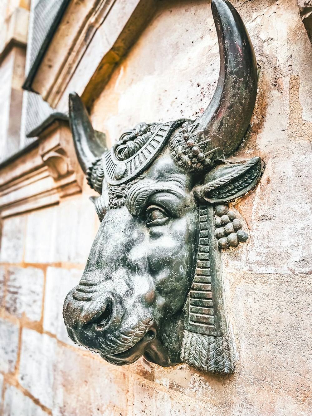 a statue of a bull's head on the side of a building