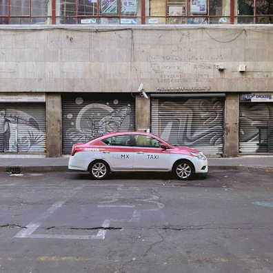 A taxi parked near a vibrant Madrid café with colorful street art in the background.