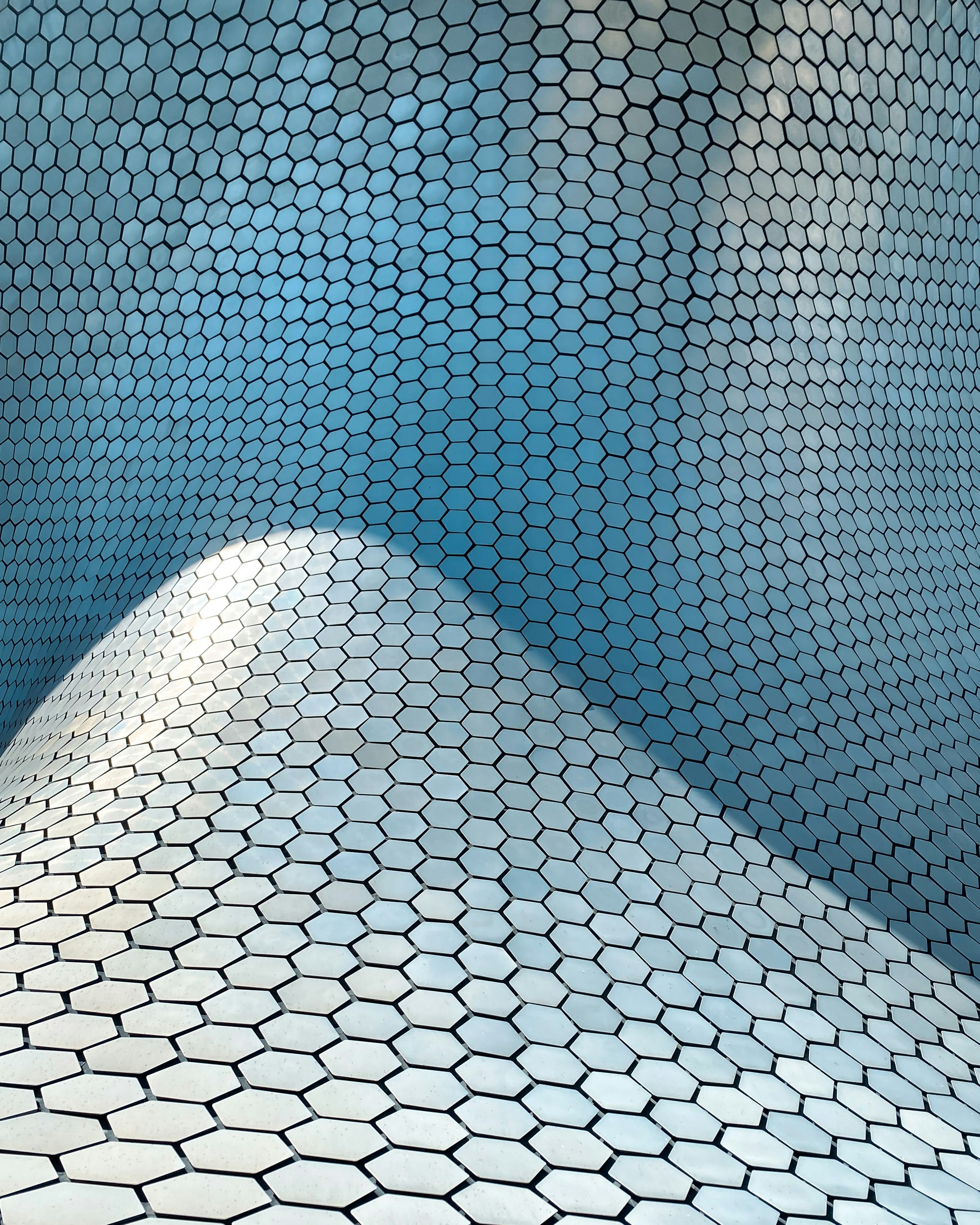 a blue and white tiled wall with a sky background