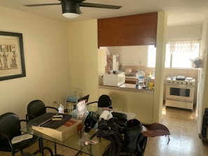 A communal kitchen with modern appliances and a dining area filled with residents.