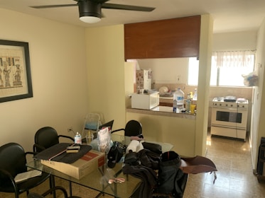A communal kitchen with modern appliances and a dining area filled with residents.