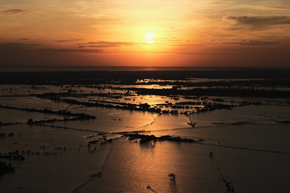 a large body of water with a sunset in the background