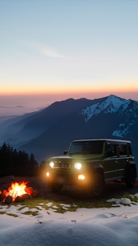 A rugged flatbed camper parked in a snowy Alaskan forest at sunset