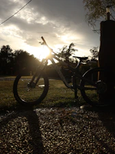Portrait of a gravel rider smiling with his bike at sunset on a rural road.