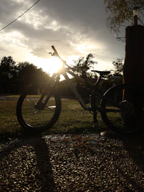 Portrait of a gravel rider smiling with his bike at sunset on a rural road.