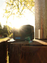 A warm, inviting photo of a camera resting on a rustic wooden table with soft natural light.