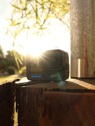 A sleek mirrorless camera resting on a wooden table bathed in soft natural light