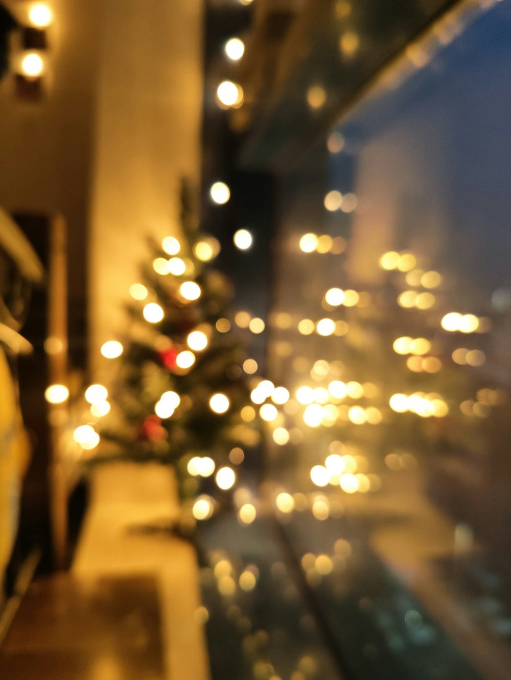 a blurry photo of a christmas tree outside a window