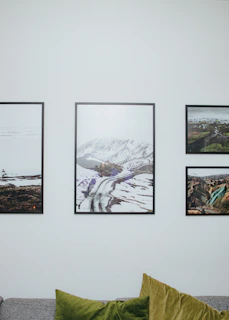 A high-definition metal poster of a minimal mountain landscape displayed above a cozy sofa.