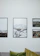 Close-up of a beautifully framed coastal photograph hanging above a cozy sofa.