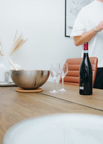 A cozy wooden table displaying elegant wine glasses and a decanter with red wine.