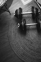 Adjustable dumbbells neatly arranged on a wooden floor with natural light streaming in