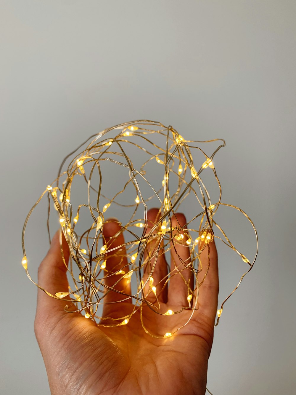 a hand holding a ball of string lights