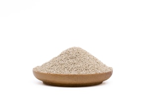 Close-up of golden wheat flour in a rustic wooden bowl with a wooden scoop