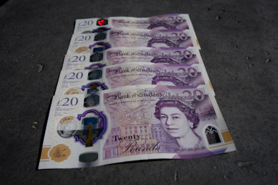 Elegant British pound notes arranged neatly with a passport beside them
