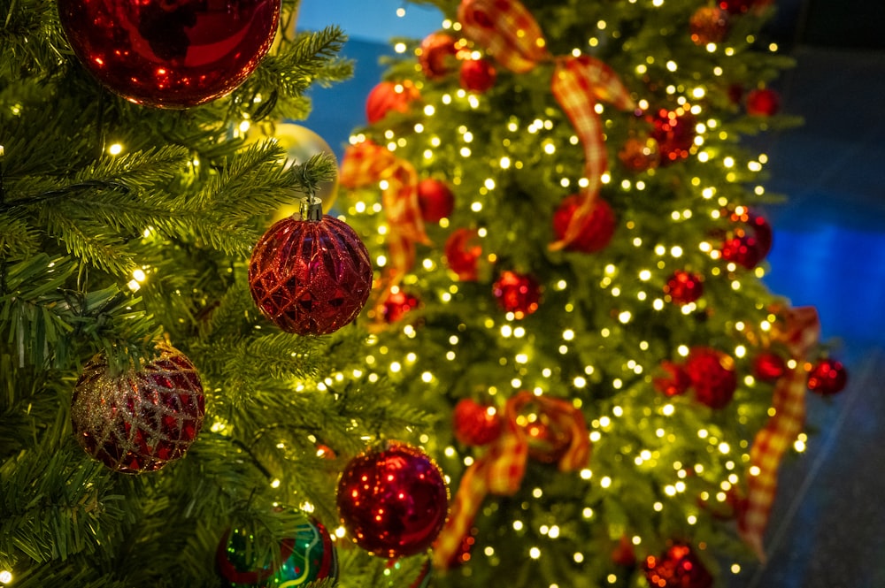 a christmas tree is decorated with red and gold ornaments