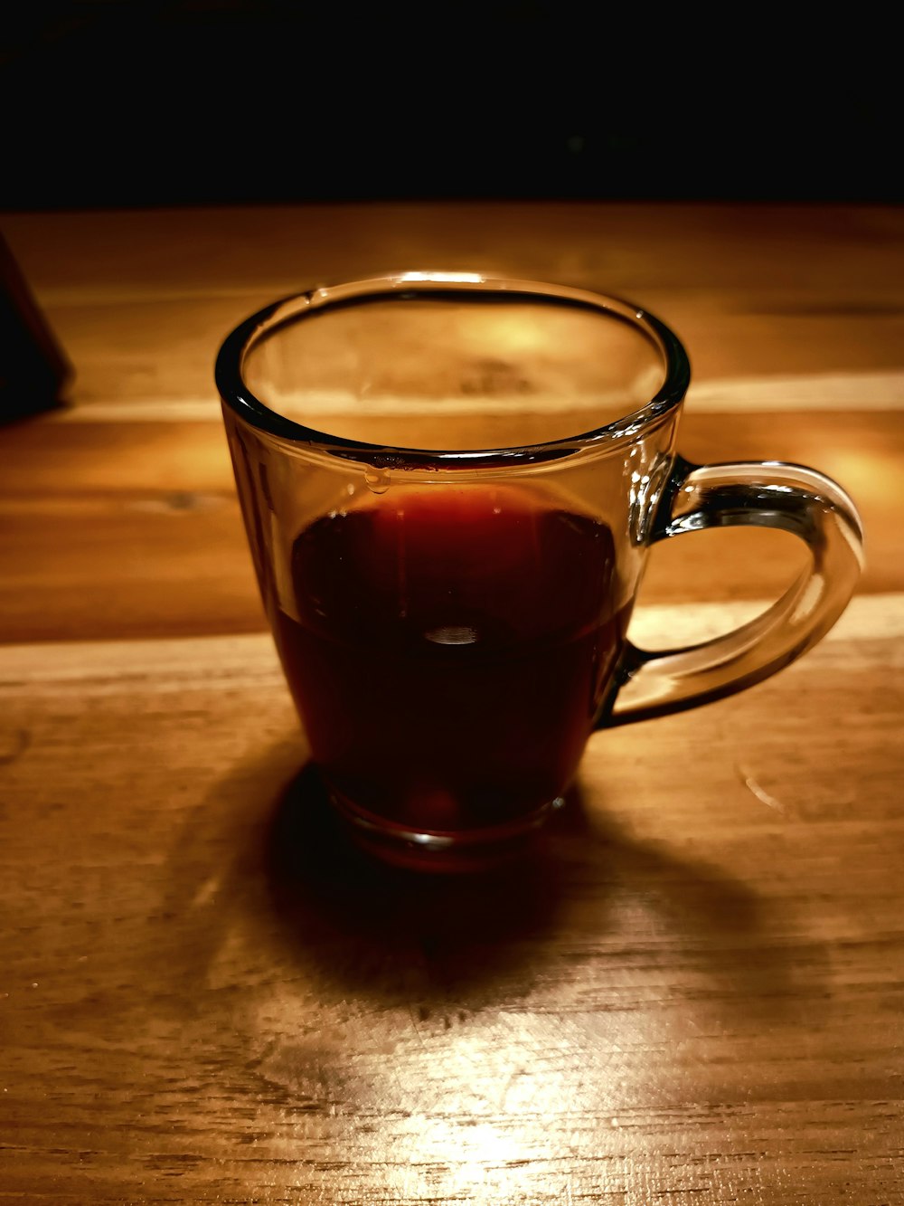 a cup of liquid sitting on top of a wooden table