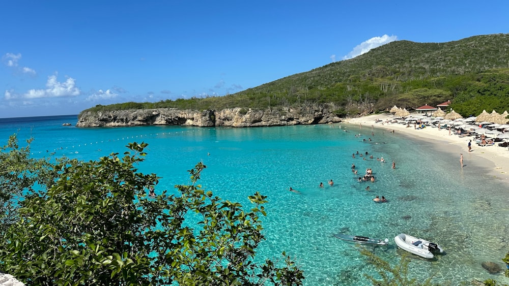 un groupe de personnes sur une plage à côté d’un plan d’eau