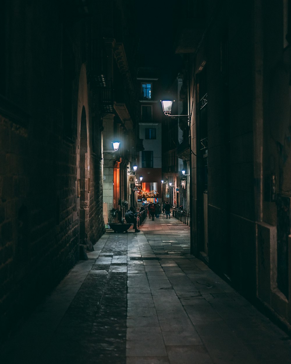 a dark alley with people walking down it at night