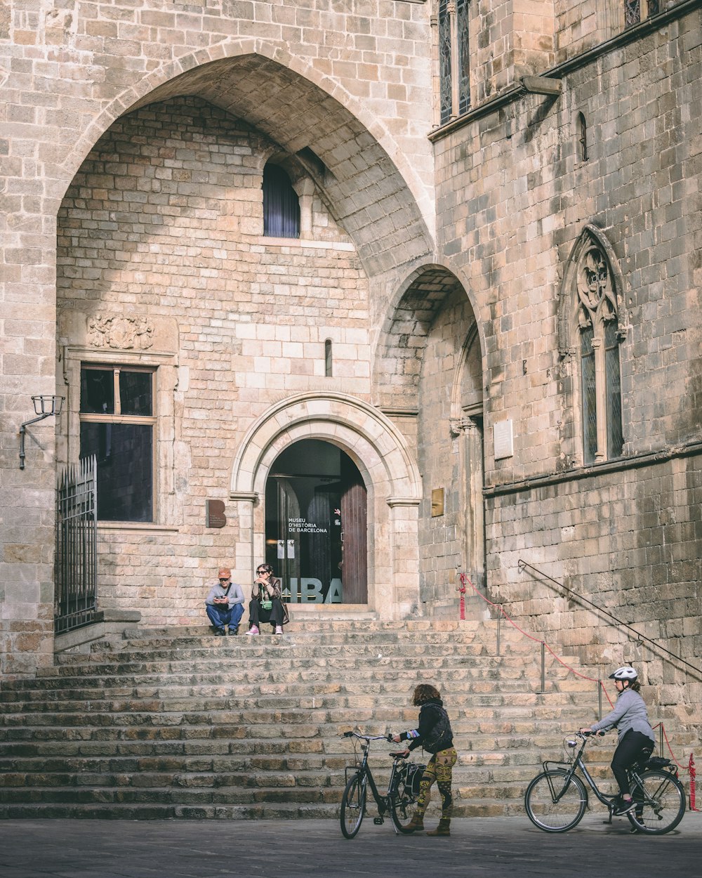 a couple of people riding bikes down a street