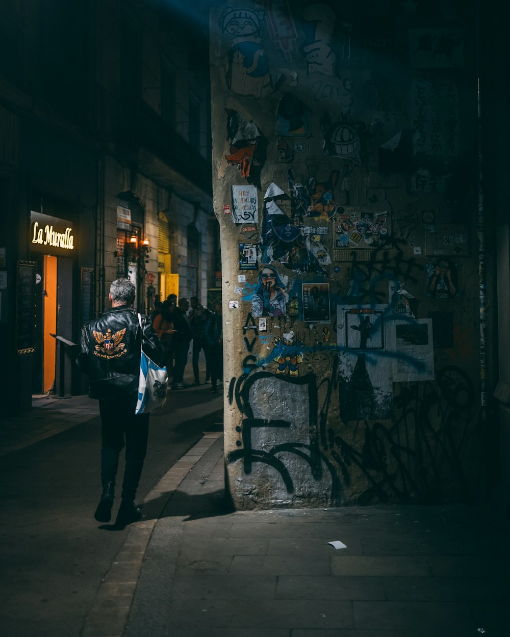 a man walking down a street at night