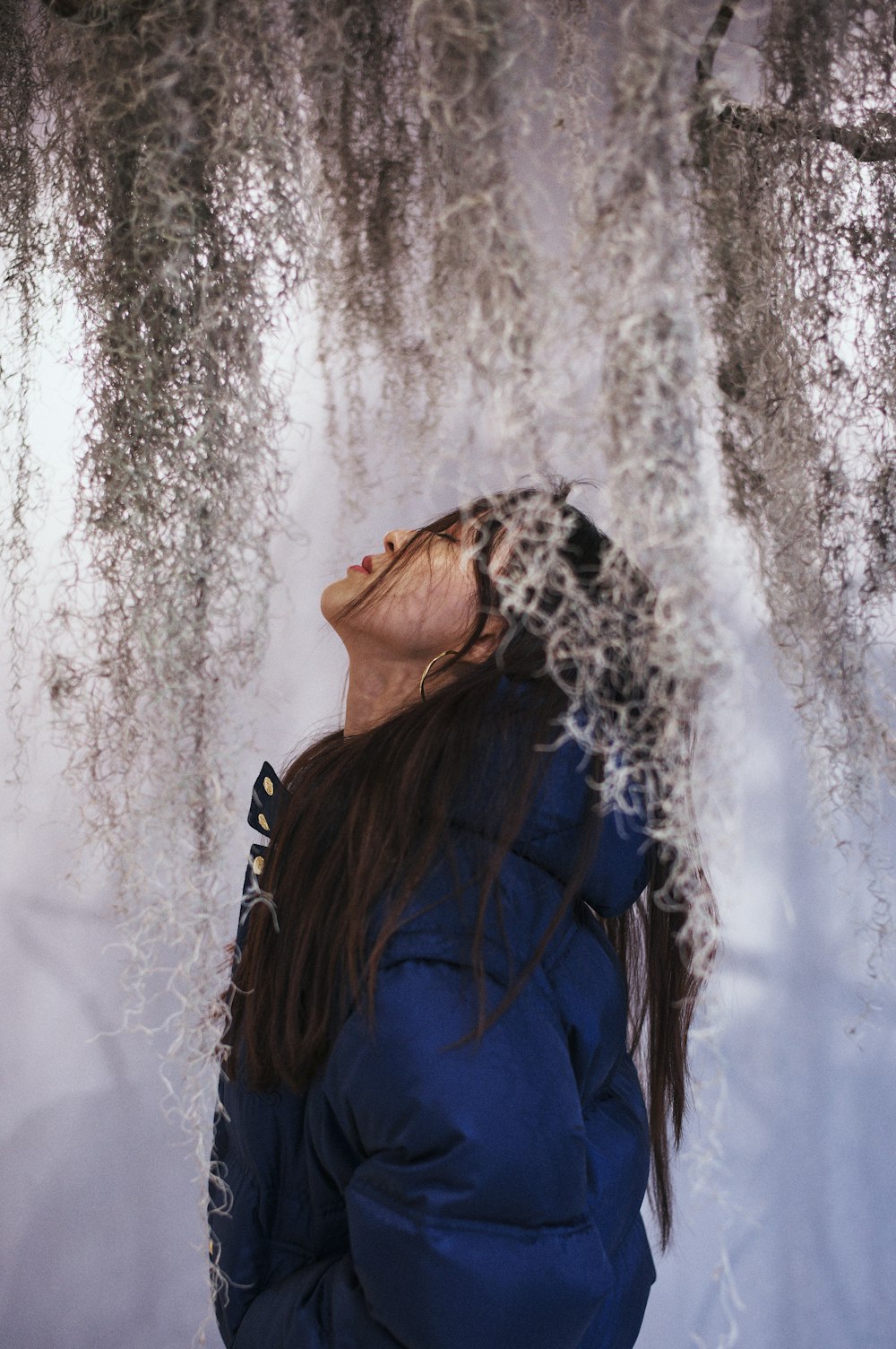 a woman standing under a tree covered in snow