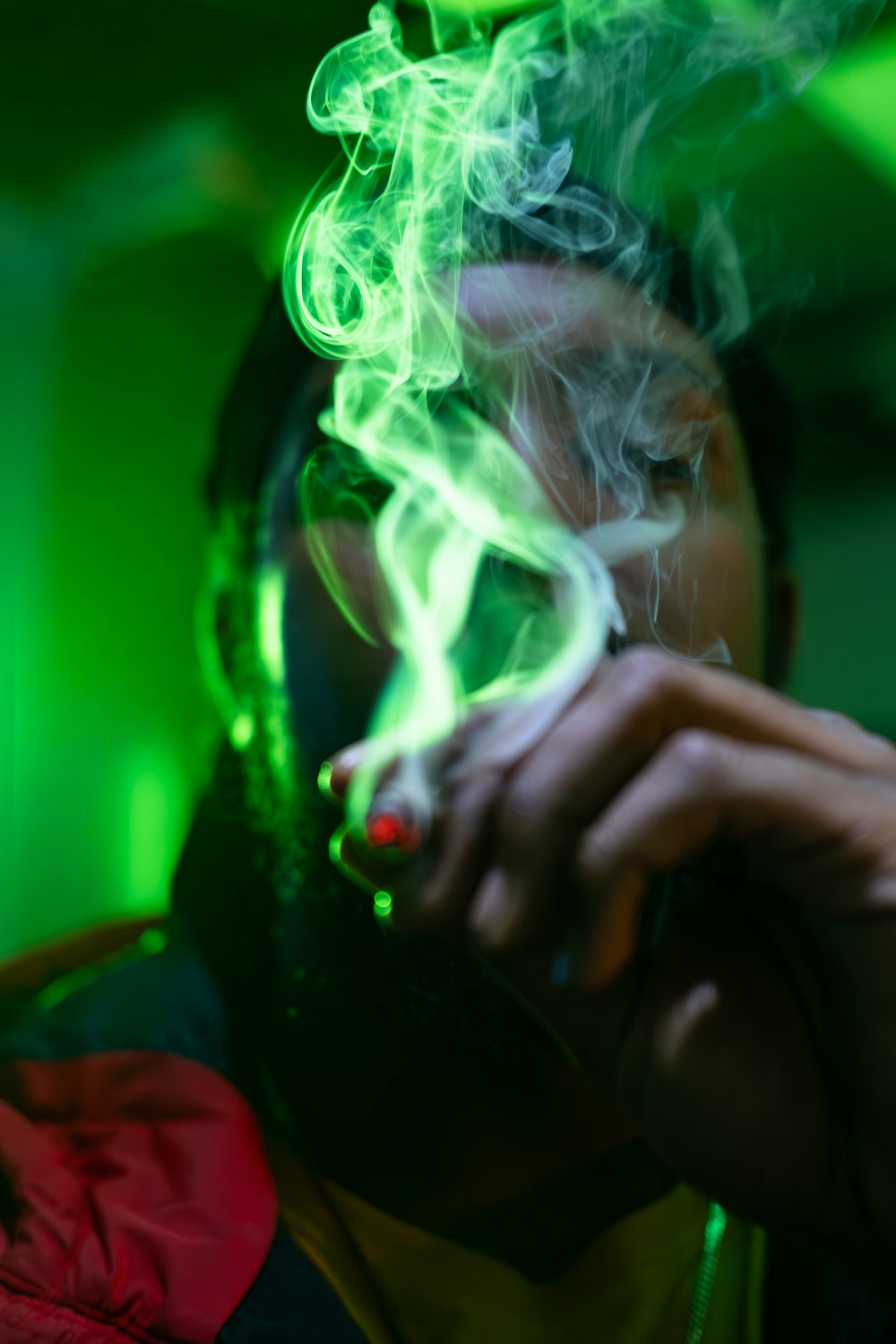 a man smoking a cigarette in a dark room