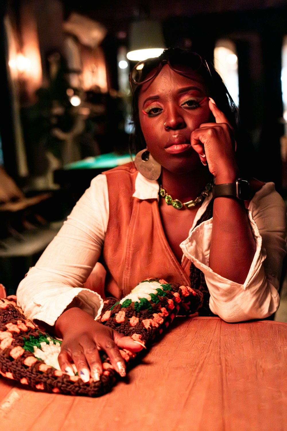 a woman sitting at a table talking on a cell phone