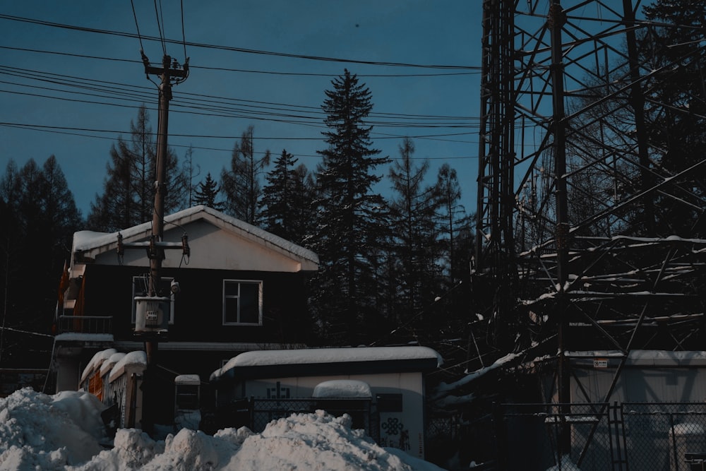 a house is surrounded by snow and power lines