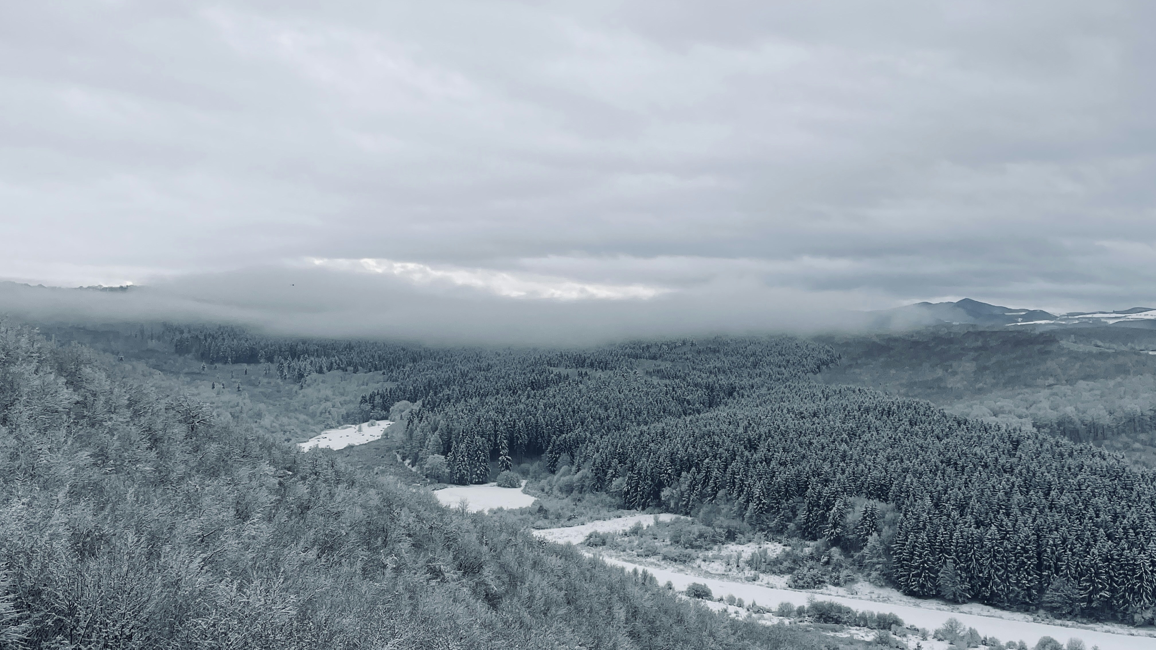 a view of a snowy mountain with a river running through it