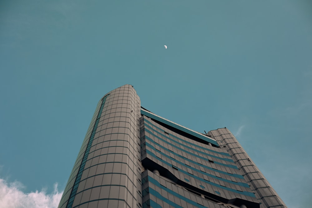 a tall building with a half moon in the sky