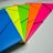 Brightly colored file folders arranged fan-like on a flat surface, each with a black elastic band securing them. The folders are in blue, yellow, green, orange, and pink colors, creating a vibrant and organized appearance.