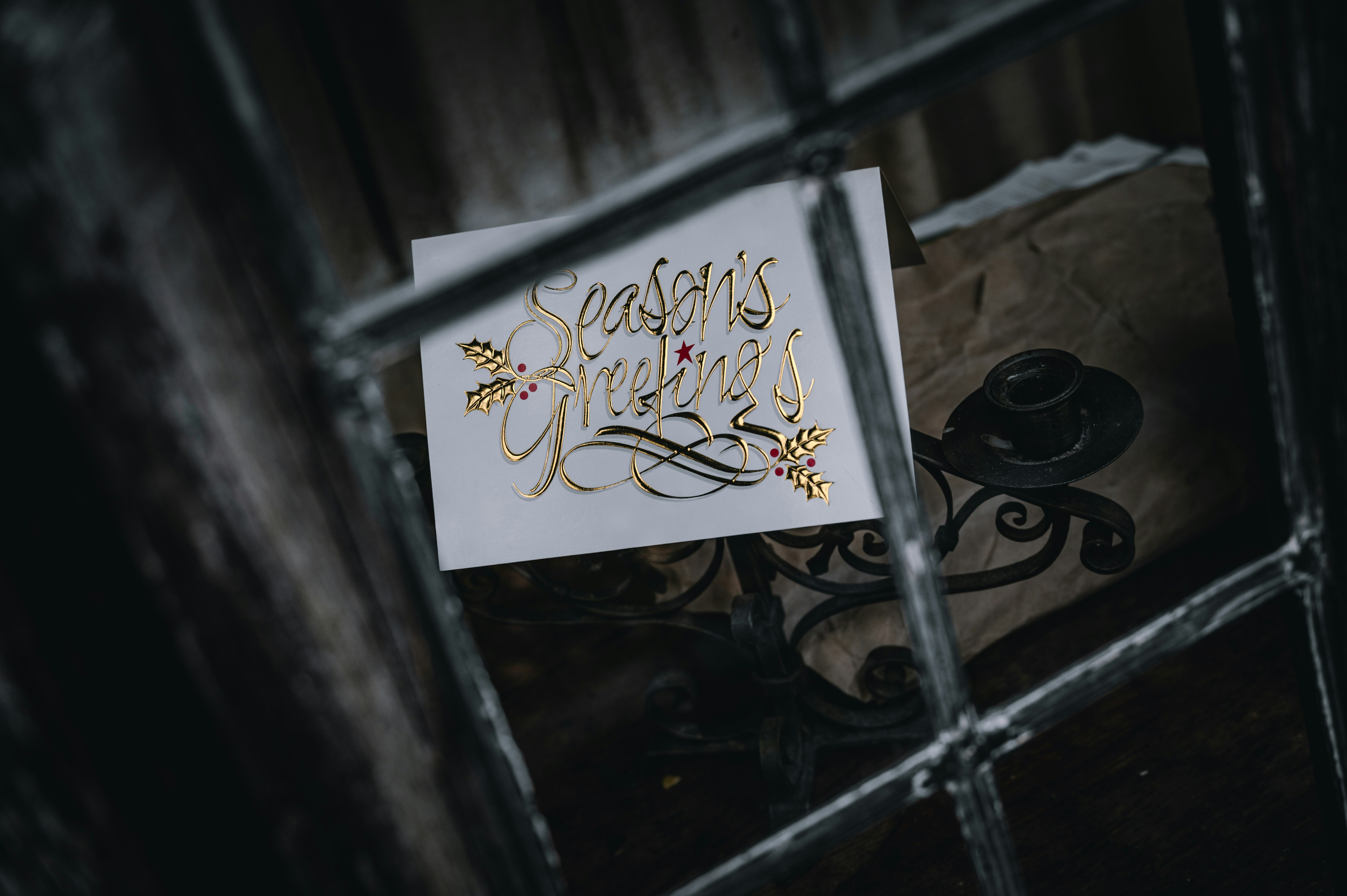 Seasons Greetings card in an old window.