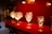 Elegant crystal wine glasses are displayed on a vibrant red shelf, with soft lighting creating a warm and inviting atmosphere. The intricate patterns on the glasses reflect the gentle light.