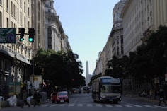 a bus driving down a street next to tall buildings