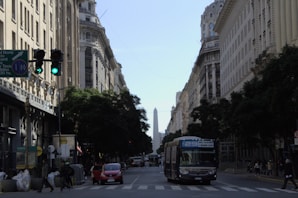 a bus driving down a street next to tall buildings
