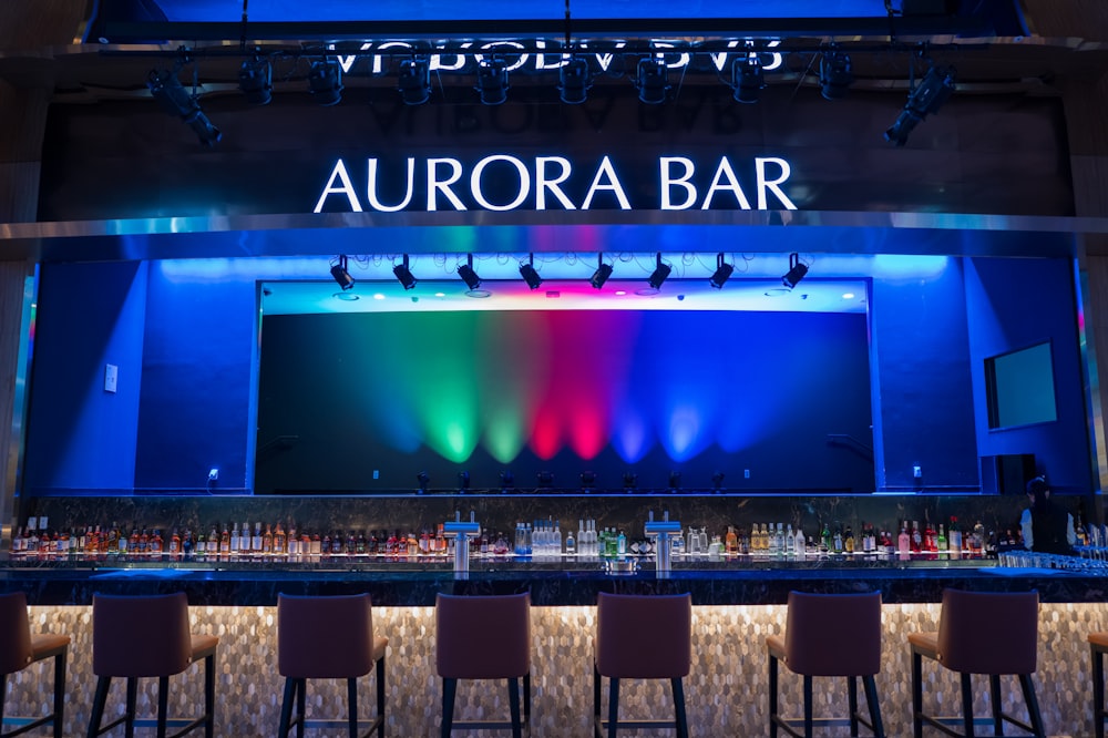 a bar with a rainbow lit sign above it