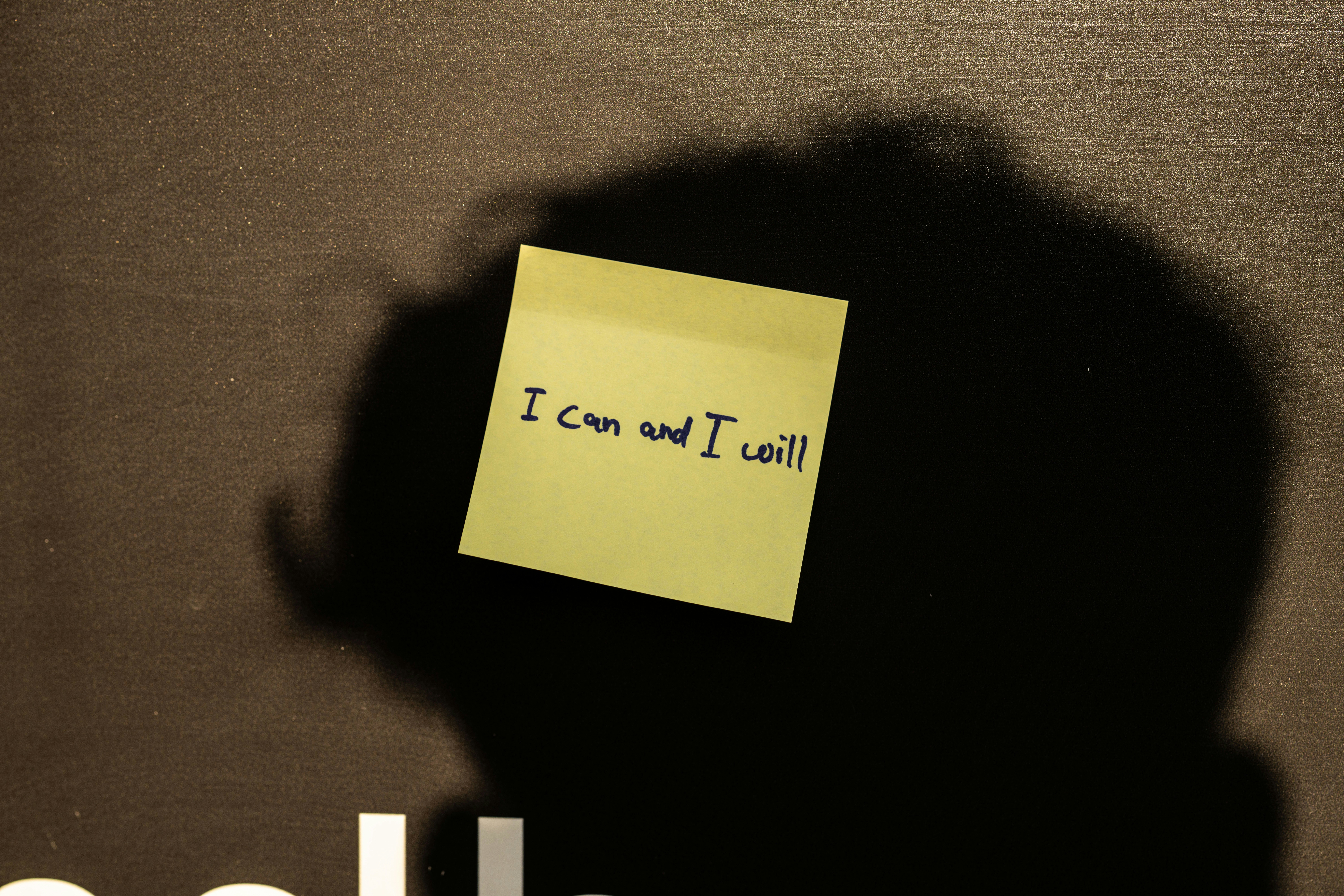 a sticky note attached to the back of a laptop