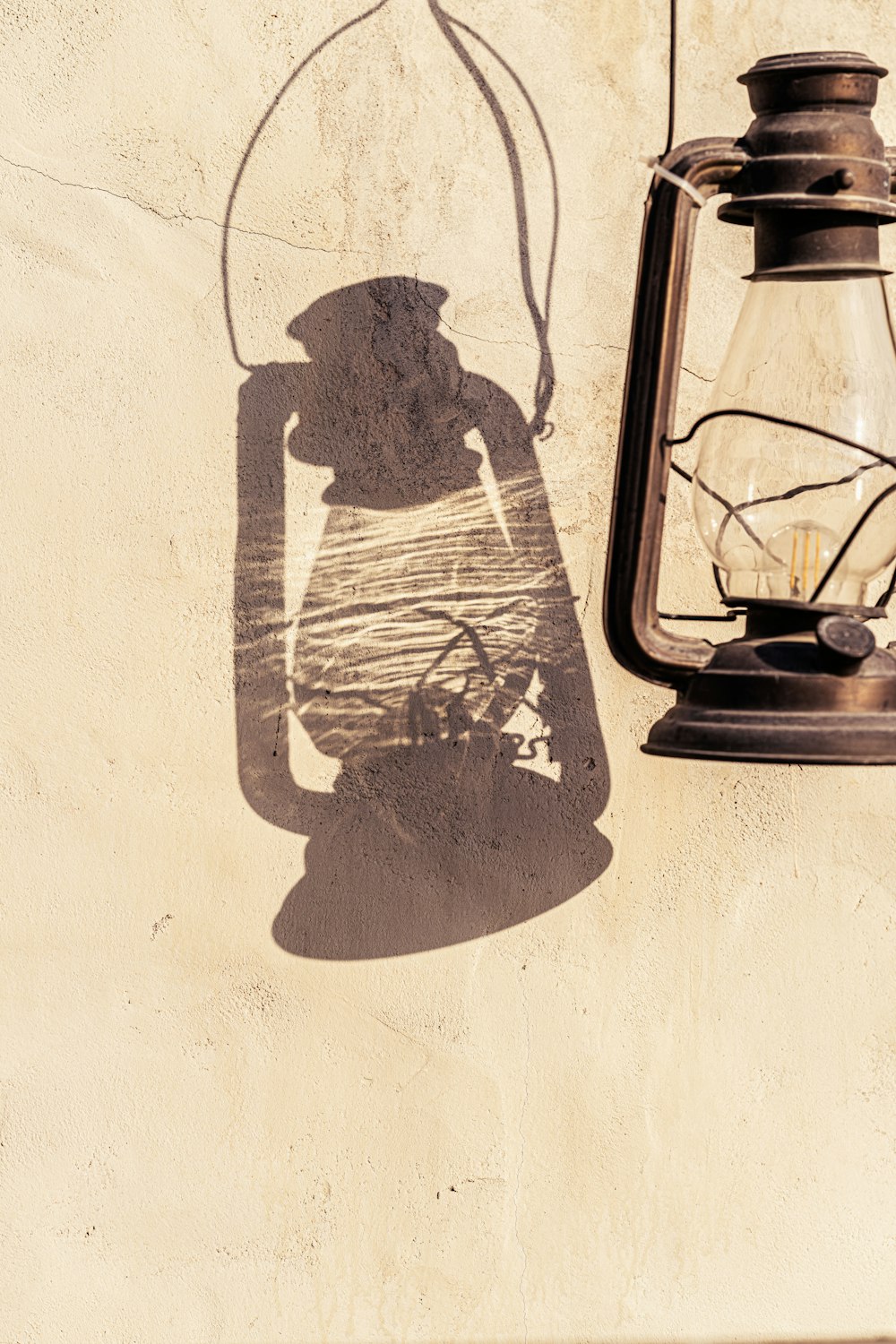 a shadow of a lantern and a lantern on a wall