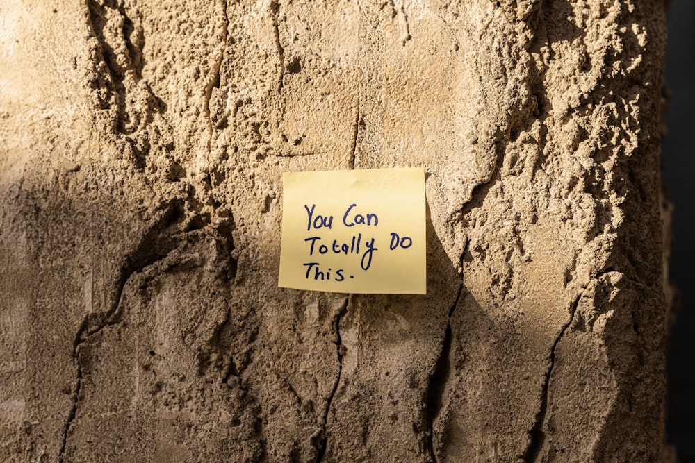 a sticky note attached to a tree trunk