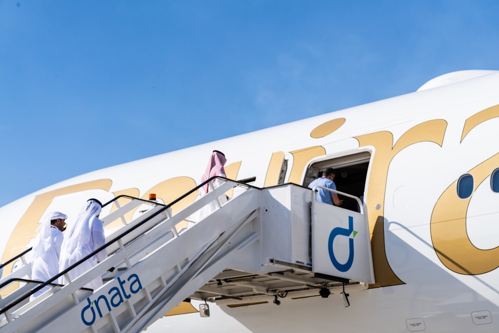 a group of people boarding a plane on a sunny day