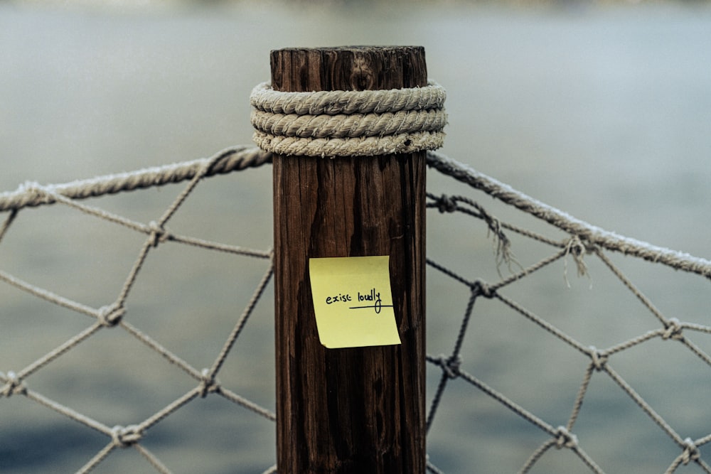 a post with a note attached to it near a fence