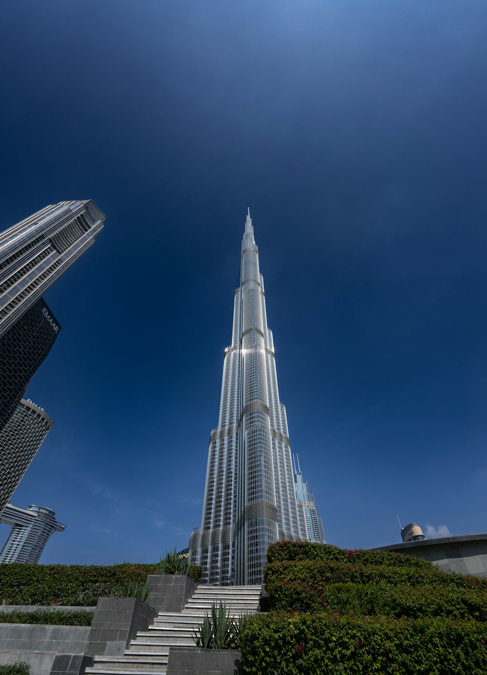 a very tall building towering over a lush green hillside