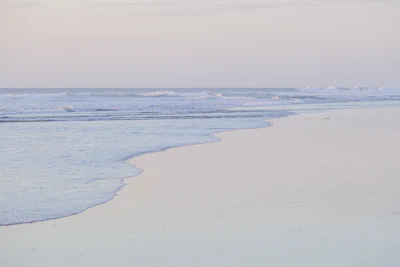 A serene beach scene captured in soft morning light, displayed in a 3:2 landscape format.