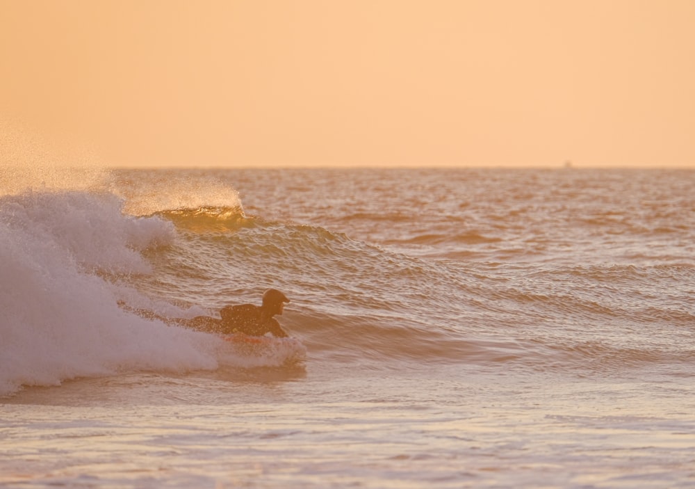 a man riding a wave on top of a surfboard