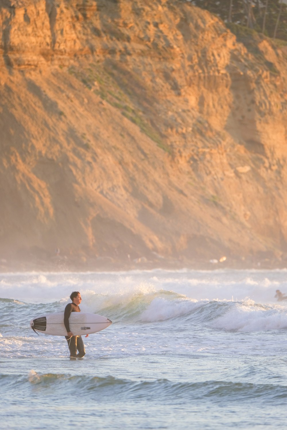 a man holding a surfboard while standing in the ocean