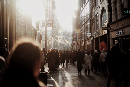 A busy urban commercial property with signage and bustling foot traffic during golden hour.