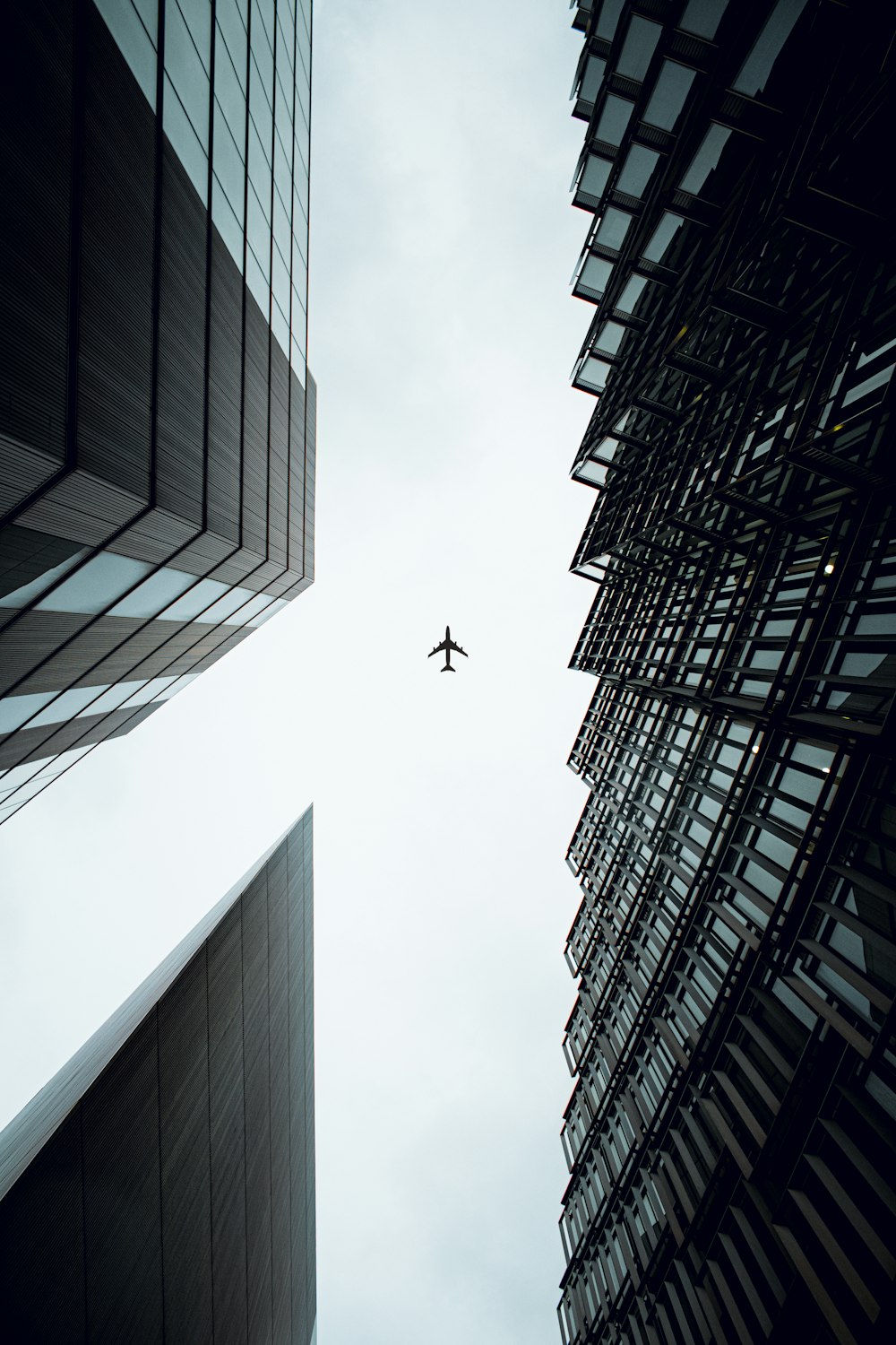 an airplane flying in the sky between two buildings